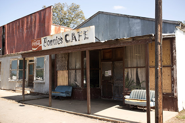Storefront and cafe building with couches on dirt road