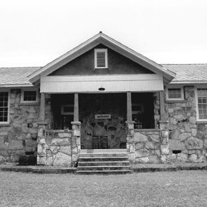 Single-story building with stone walls and covered porch