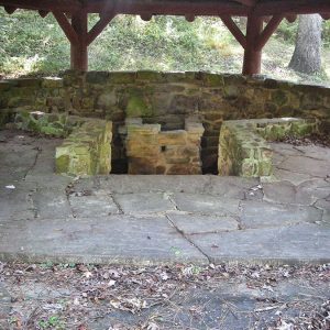 Interior of wood and stone pavilion with open fire pit
