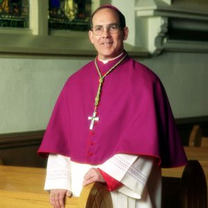 White man wearing bishop's robes inside a church