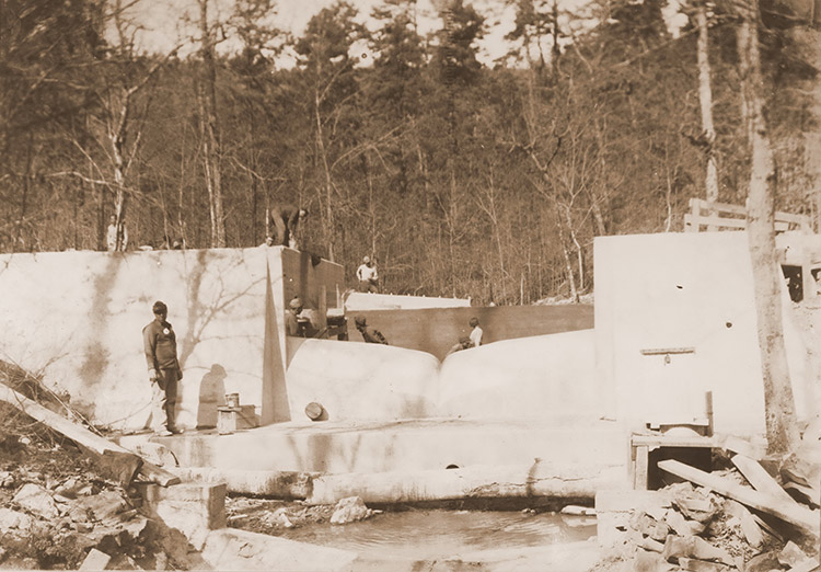 White workers on concrete platforms in wooded area