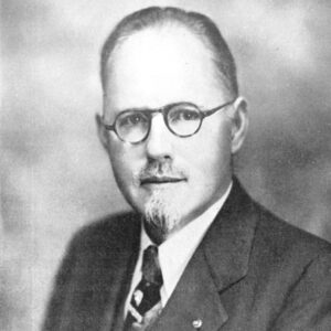 White man in glasses with mustache in suit and tie