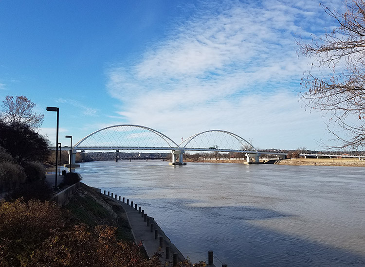 Steel arch bridge over river as seen from shore
