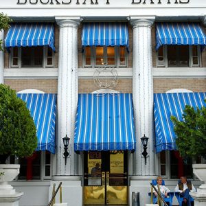 Three-story building with columns and blue awnings