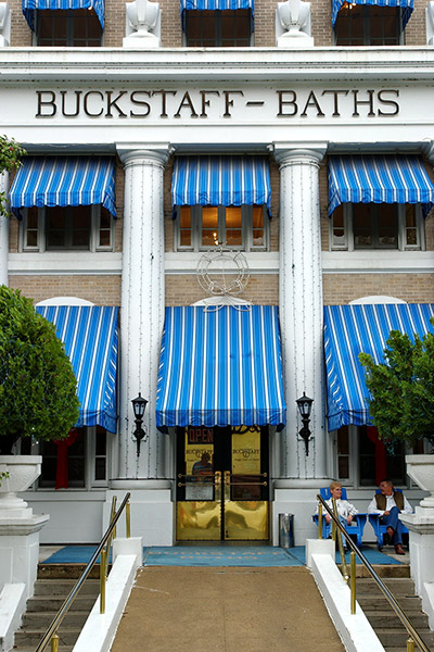 Three-story building with columns and blue awnings