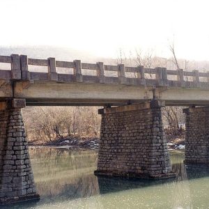 Concrete bridge with stone supporting columns over river