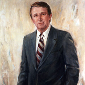 White man with brown hair in blue suit and a striped tie