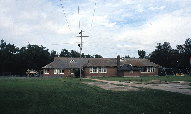 Brick buildings with swing set and power lines