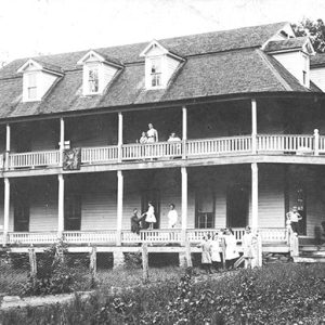 Three story hotel with covered porch and balcony