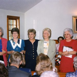 Group of white women standing in church sanctuary