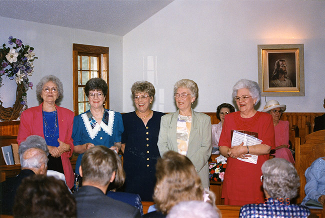 Group of white women standing in church sanctuary