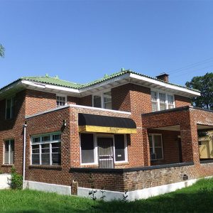 Multistory brick building with covered porch on street
