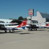 Red-white-and-blue airplanes at airport and "Phillips 66" sign with building in the background