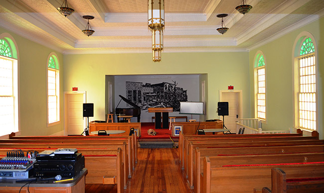 Interior church building with pews and piano on stage