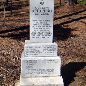 Three-tier stone monument with Masonic symbol and engraving saying "Camp White Sulphur Springs War Masons" with names