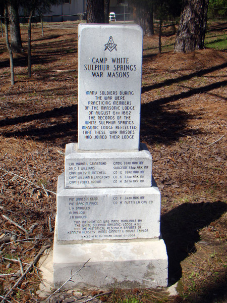 Three-tier stone monument with Masonic symbol and engraving saying "Camp White Sulphur Springs War Masons" with names