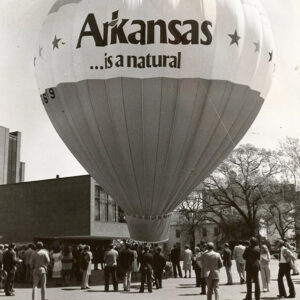 "Arkansas is natural" hot air balloon on street with crowd