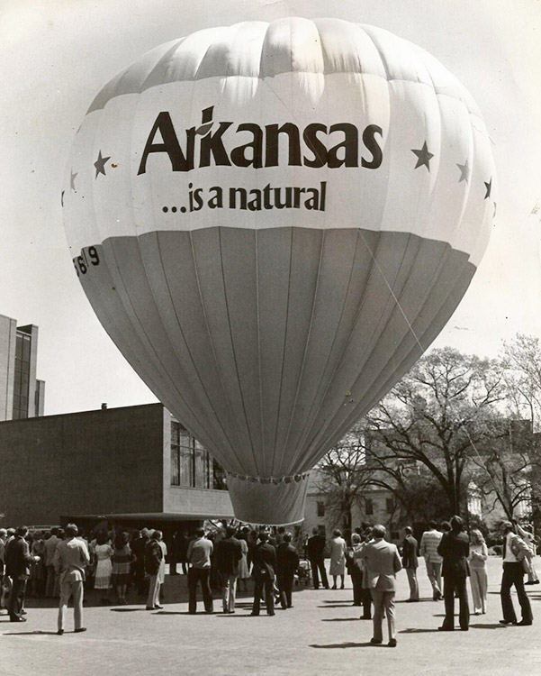 "Arkansas is natural" hot air balloon on street with crowd