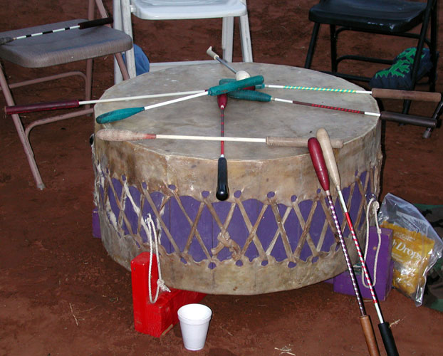 Large round drum with chairs around it and sticks crossed on top