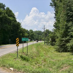 "Caddo Gap" sign and road signs on two-lane highway