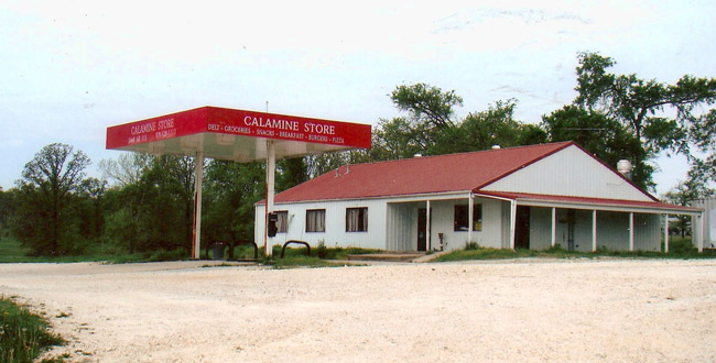 Single-story building with red canopy with "Calamine Store" written on it