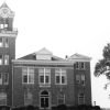 Multistory brick building "Calhoun County Court House" with tall clock tower and arched entrance