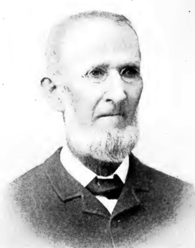 faded black and white photo of older white man with round glasses and beard in suit jacket