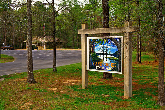 Building with sign and parking lot "Cane Creek State Park"