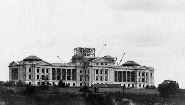 Four-story marble building with dome under construction