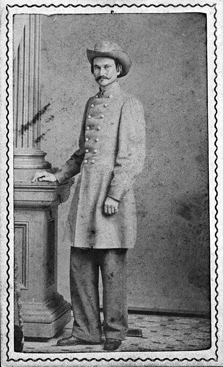 White man in gray military uniform and hat standing with column