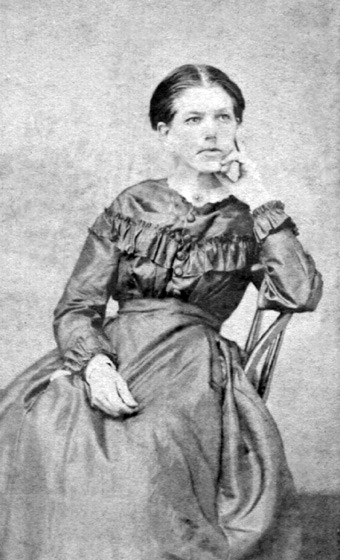 portrait of white woman in dress sitting in chair