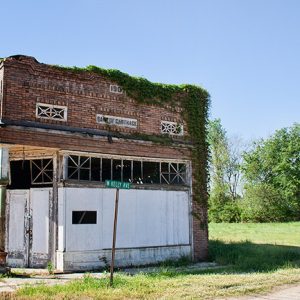 Abandoned run-down brick building on grass