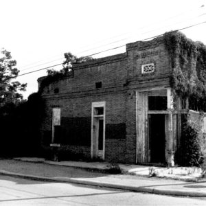 Side view of abandoned storefront with vines growing on it