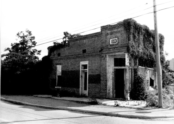 Side view of abandoned storefront with vines growing on it