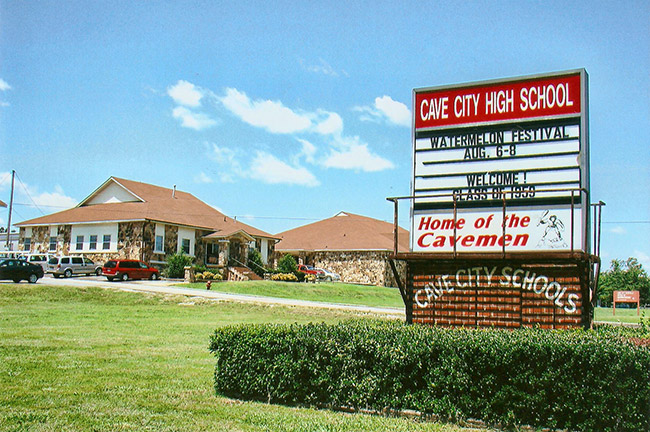 buildings with rock walls and sign with bushes