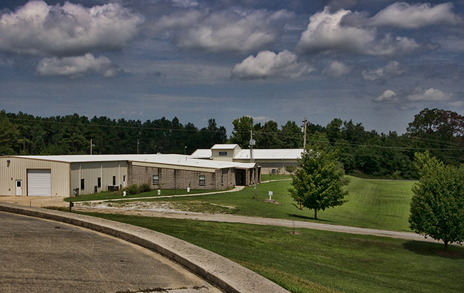 Side view of single-story buildings and garage building on school campus