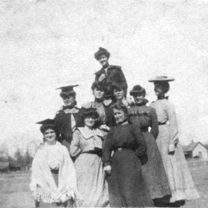 Multiple women posing in dresses outdoors