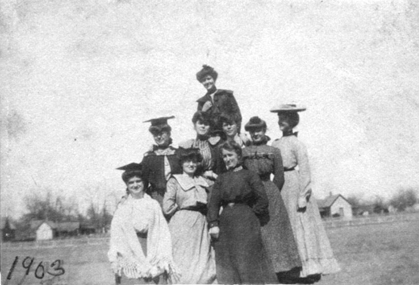 Multiple women posing in dresses outdoors