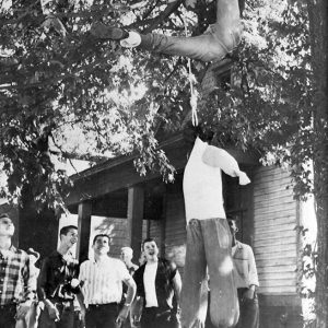 Group of young white men hanging an effigy from a tree