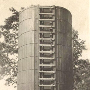 Silo with rungs for climbing and trees in background