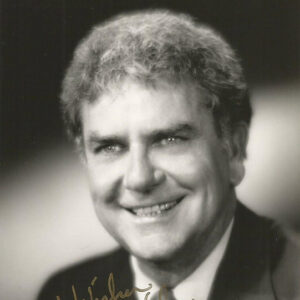 White man smiling in suit and tie signed "Best wishes Charlie Daniels 3-17-95"