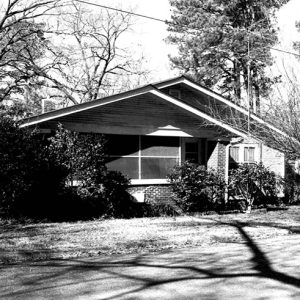 Single-story house with screened-in porch and tree in front yard