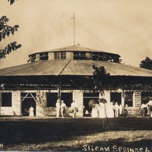 Round building with skylight and crowd of people standing outside labeled "auditorium Siloam Springs"