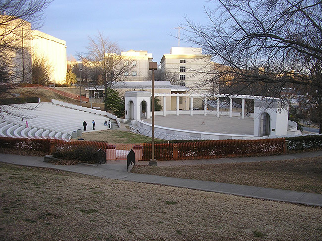 Open air amphitheater on college campus with trees and surrounding buildings