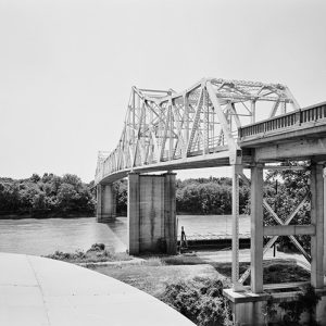 Steel truss bridge with concrete supports over river