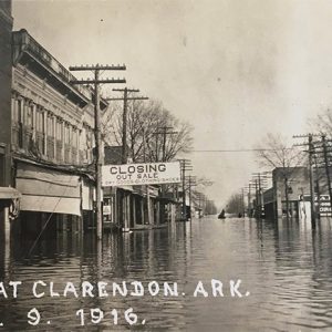 Flooded street with town buildings storefronts and power lines