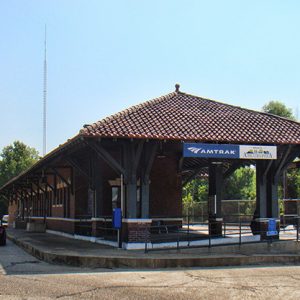 "Amtrak" train station building with pavilion and parking lot