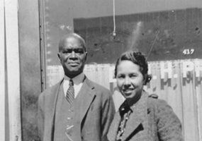 African-American man and woman in suit and long coat respectively