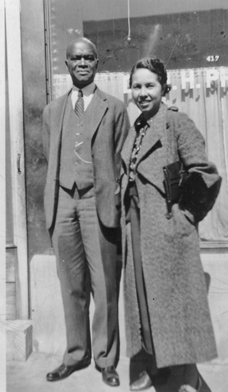 African-American man and woman in suit and long coat respectively