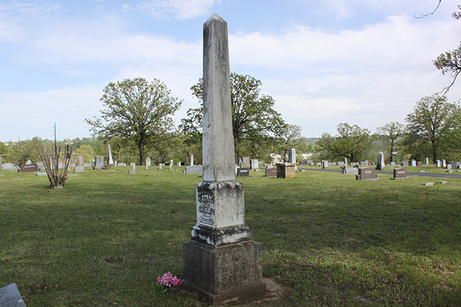 Weathered obelisk shaped monument in cemetery